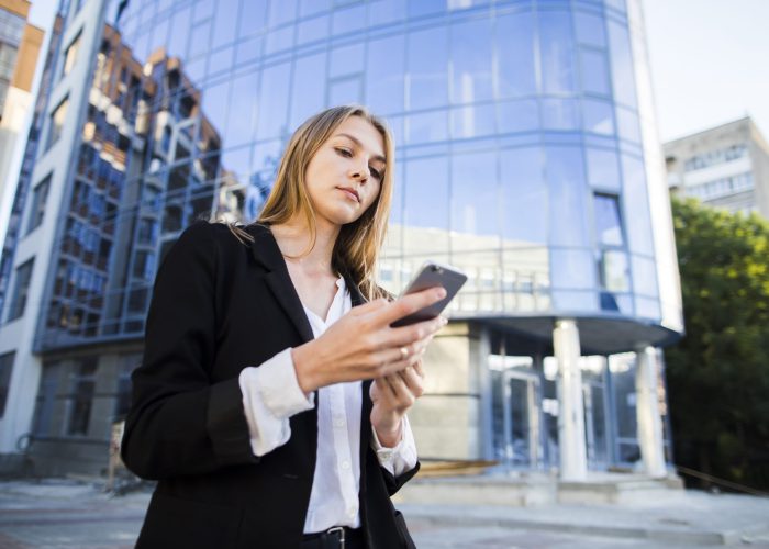 young-woman-using-her-phone-low-angle-shot